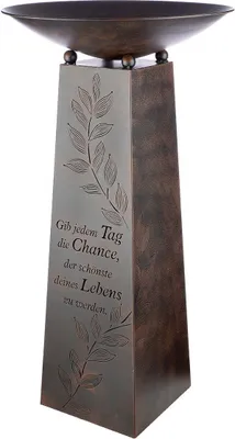 A decorative metal stand with a bowl on top, featuring engraved text and floral designs.