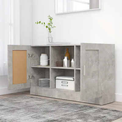 A grey sideboard with open doors and shelves filled with various items, placed on a rug in a room with natural light coming from a window.
