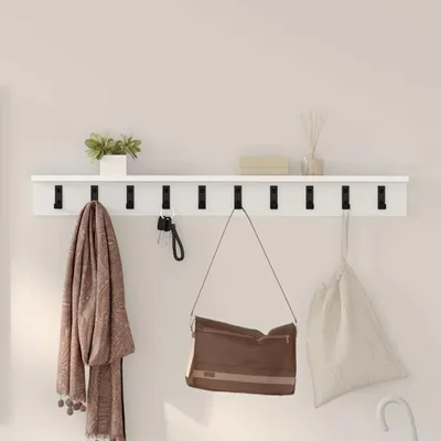 A white shelf with hooks mounted on a light gray wall, displaying a scarf, keys, a handbag, and a canvas bag.