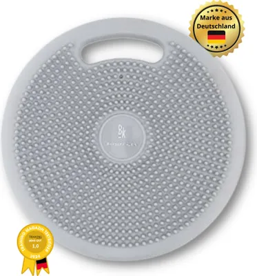 A light gray balance board with a textured surface and a handle, shown on a white background with promotional badges.