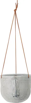 A hanging planter pot with a face-like design.
