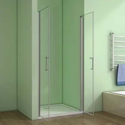 A modern bathroom with a glass shower enclosure against a light green wall.