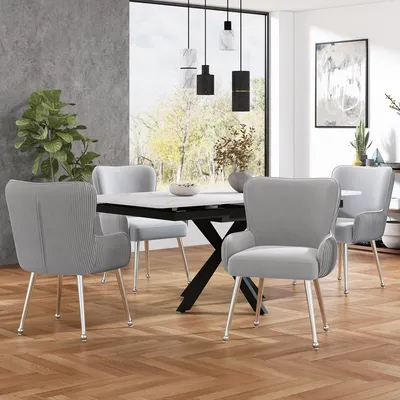 A dining room setting with a table and chairs, featuring a large window with a view of trees.