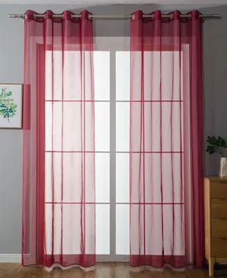 A room with a window covered by sheer red curtains.