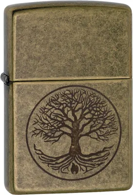 A close-up, front-facing view of a Zippo lighter with an antique brass finish, featuring an engraved 'Tree of Life' design.