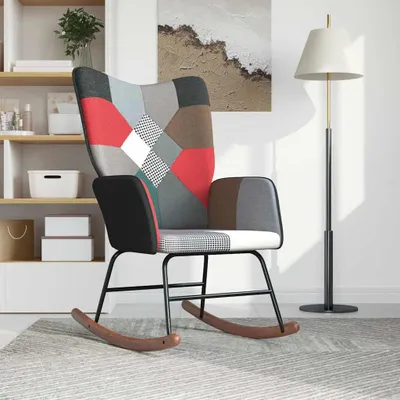 A patchwork rocking chair is shown in a room with shelves and a floor lamp.