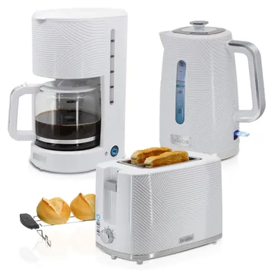 A set of white kitchen appliances including a coffee maker, kettle, and toaster, with two bread rolls on a rack in the foreground.