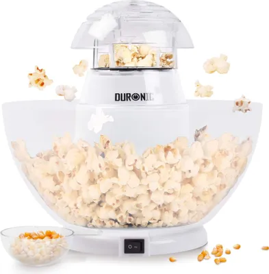 A white popcorn maker with a clear bowl, making popcorn.