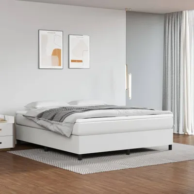 A white bed frame with a mattress and bedding is shown in a bedroom setting.
