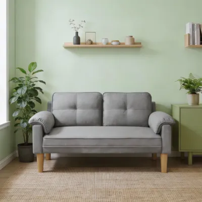 A light green room with a gray sofa, plants, and shelves.