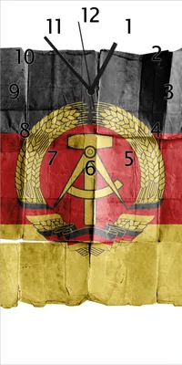 Produktbild von Wallario Design Wanduhr bedruckt, Größe 30 x 60 cm, Motiv: DDR Flagge auf altem Papier - schwarz rot gold