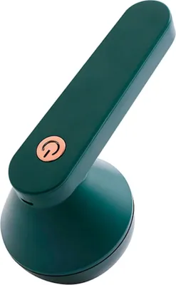 A dark green fabric shaver with a copper power button is shown against a white background.