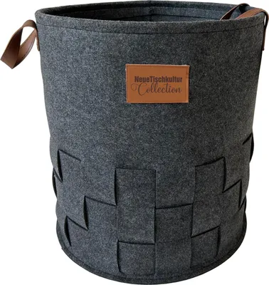 A dark gray felt laundry basket with brown leather handles and a brown leather tag with text.