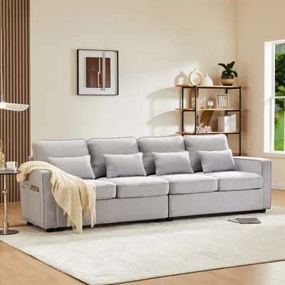 A modern living room with a large gray sofa, a shelf unit with decor, and a window.