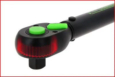 A close-up shot of a torque wrench with green buttons and red markings.