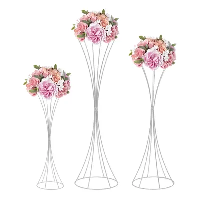 Three silver flower stands of varying heights, each topped with a bouquet of artificial flowers in shades of pink, peach, and white.