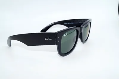 A pair of black sunglasses with green lenses is displayed against a white background.
