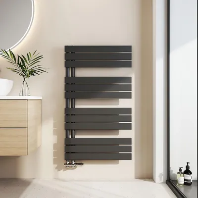 A modern bathroom with a dark gray towel radiator mounted on a light beige wall.