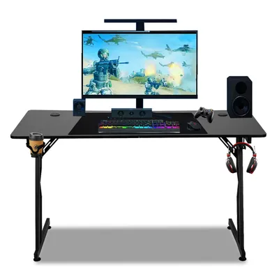 A gaming desk setup with a monitor, keyboard, mouse, speakers, and headphones.