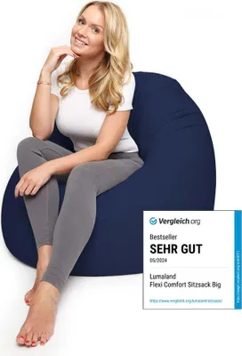 A woman is sitting on a navy blue beanbag chair.