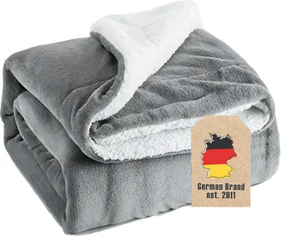 A folded gray and white sherpa blanket is shown.