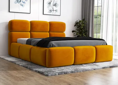 A yellow upholstered bed with a gray rug and two framed pictures on the wall.