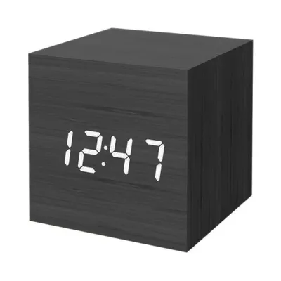 A black digital alarm clock with a wood grain texture is shown against a white background.