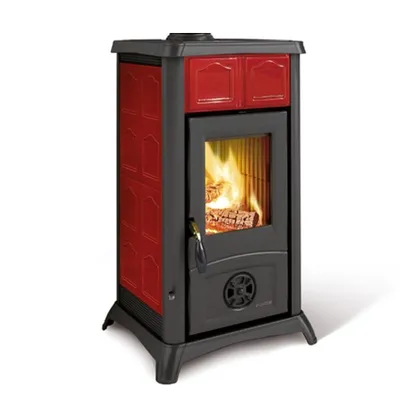A freestanding wood-burning stove with a red ceramic facade and a black metal body, showing a fire burning inside.