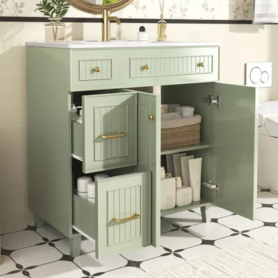 A green bathroom vanity with its doors and drawers open, showcasing storage space and toiletries.