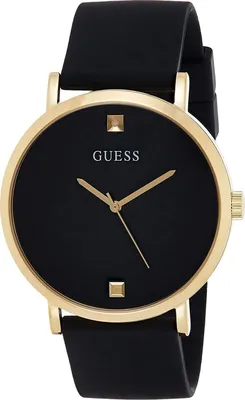 A close-up studio shot of a black and gold Guess watch against a white background.