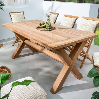 An outdoor dining set with a wooden table and chairs on a patio.