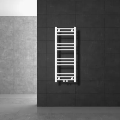 A white towel radiator is mounted on a dark tiled wall in a modern bathroom setting.