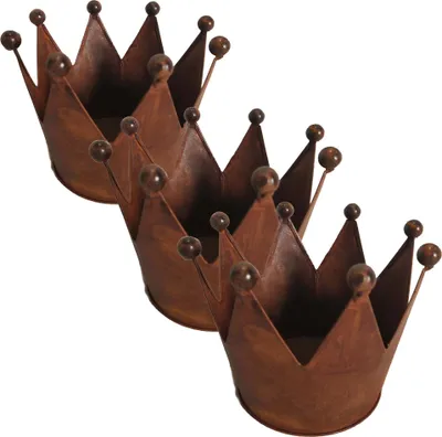 Three rusty metal crown-shaped planters are arranged diagonally on a white background.