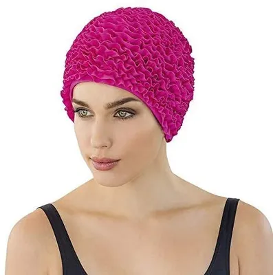 A woman wearing a pink ruffled swim cap.