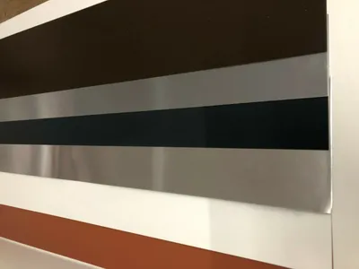 A close-up view of a metal sheet with horizontal stripes of different colors.