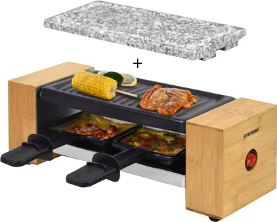A raclette grill with a granite stone top, shown with food items on the grill and in the raclette pans.