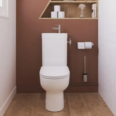 A clean, modern bathroom setting with a white toilet and sink combination unit.