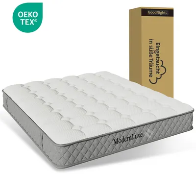 A mattress is shown in front of a cardboard box with text and a logo.