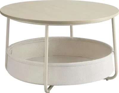 A round coffee table with a woven fabric basket underneath.