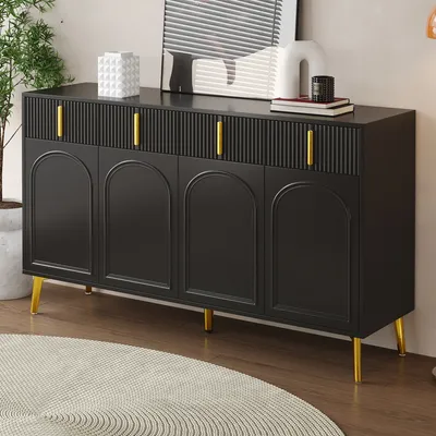 A black sideboard with gold handles is shown in a room with a plant and a rug.