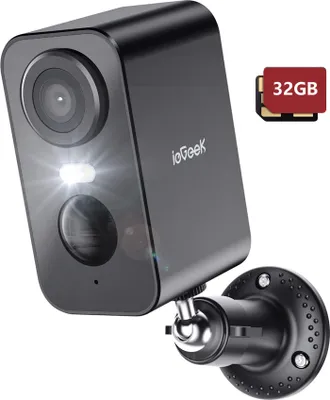 A black security camera with a white LED light and a lens, mounted on a black bracket. A small graphic of two SD cards labeled '32GB' is in the upper right corner.
