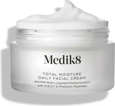 A white jar of Medik8 Total Moisture Daily Facial Cream with the lid slightly ajar and cream overflowing.