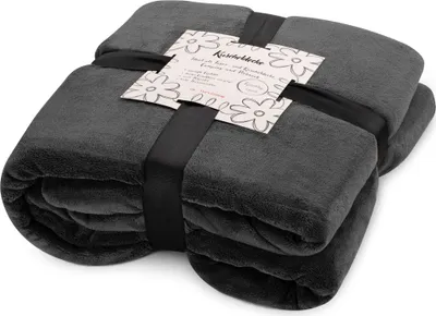 A folded dark gray blanket is tied with a black ribbon and has a product tag attached.
