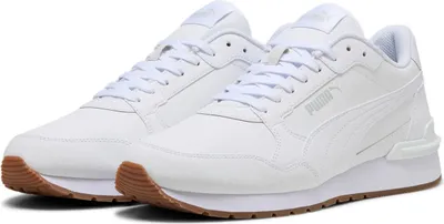 A pair of white Puma sneakers with brown soles is displayed against a white background.