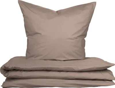 A stack of taupe bedding, including a pillow and folded duvet or comforter, is presented against a white background.