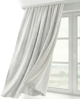 A white curtain hangs in front of a window, partially obscuring the view of a landscape outside.