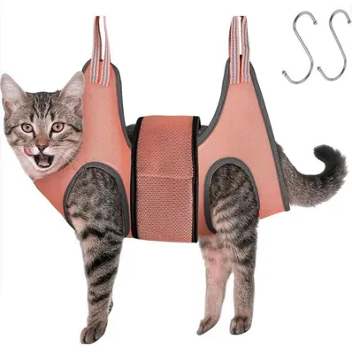 A cat is shown wearing a pink grooming hammock, with two S-hooks visible in the upper right corner.
