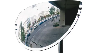 A convex mirror reflecting a street scene with buildings and cars.