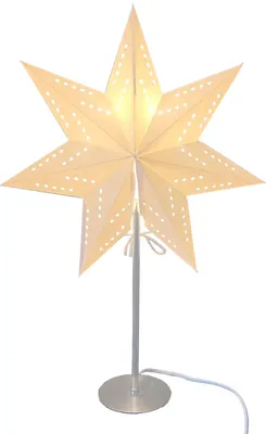 A white paper star lamp with small perforations, lit from within, stands on a silver base with a white cord.