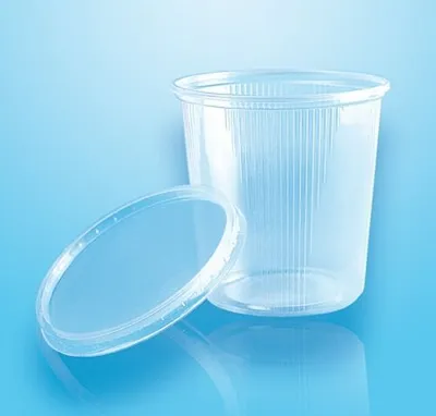 A clear plastic cup with a lid next to it, on a blue background.